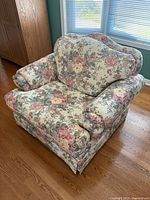 Front angled view of floral upholstered armchair showing overall design and condition