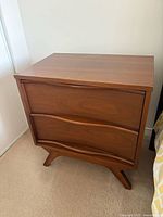 Front view of one nightstand showing drawer fronts and base