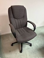 Front view of grey executive office chair showing upholstery, armrests, base