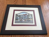 Full view of framed and matted farmhouse print on wooden floor