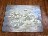 Front view of lotus canvas painting laid flat on hardwood floor