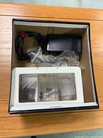 Box containing foot pedal, power cord, extension table and small accessories