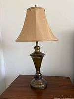 Full view of brass-tone table lamp with shade