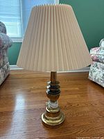 Full view of brass and glass table lamp with pleated shade
