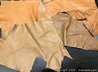 Top view of three assorted leather pieces showing grain side