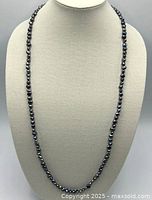 Front view showing full length strand of dark freshwater pearls on bust