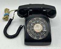 Front view showing rotary dial, handset, cords