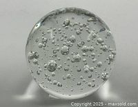 Full view of clear glass paperweight showing bubble pattern