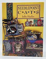 Front cover showing title, author and cat needlepoint images