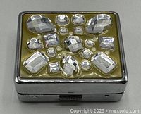 Closed pill box showing rhinestone-decorated lid