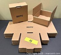 Stack of flat box sheets with one assembled and one partially assembled on top