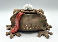 Front view of frog pottery coin bank showing eyes, tongue, body texture
