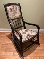 Three-quarter view of full rocking chair showing wood frame, upholstery and overall wear