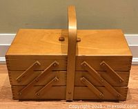 Closed wooden sewing basket showing handle and exterior