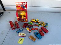 Group shot of boxed Snoopy vehicle and loose diecast cars and buses