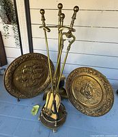 Full view of brass fireplace tool set with chargers behind