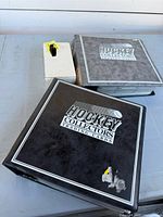 Two black binders labelled Hockey Collectors Trading Cards beside a small white card box
