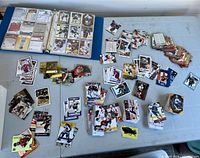Overview of binder and loose stacks of hockey cards on table