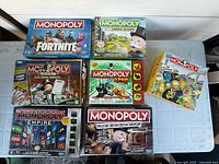 Seven Monopoly game boxes displayed on table