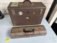 Closed brown toolbox and closed rusted toolbox
