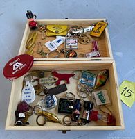 overall view of wooden box open showing lift-out tray and assortment of keychains