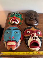 Four masks laid out with measuring tape for scale