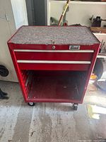 Front view of red Beach rolling tool cabinet showing missing bottom drawer and casters