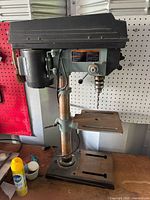 Full view of Delta benchtop drill press showing base, column, table, motor and head