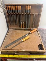 Open wooden case displaying rows of metal files and rasps with wooden handles