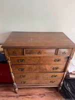 Frontal view of highboy dresser showing five drawers, hardware, and turned posts