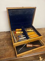 Overall view of open wooden case showing chisels, drawer, and mallet