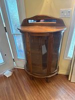 Full view of curved glass oak cabinet front and sides