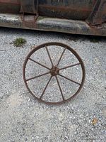 Front view of entire steel wheel showing eight spokes and rusted surface