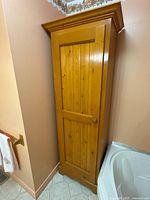 Front view of tall pine cabinet in corner
