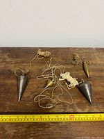 All four plumb bobs with ruler for scale