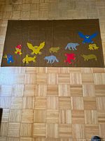 Full view of brown fabric tapestry with appliqué animals