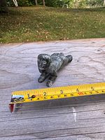 Top view of soapstone figurine with tape measure showing length