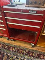 Front view of red Stanley rolling tool cabinet on casters showing missing bottom drawer