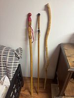 Three walking sticks leaning against wall showing overall forms