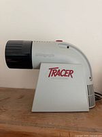 Left side view showing Tracer logo and lens