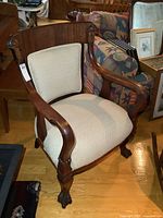 Front view showing carved crest rail, upholstery, and claw feet