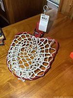 Overall view of red clamp-on hoop net with tag