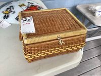 Closed wicker sewing box showing label and clasp
