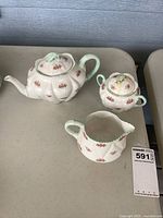 Teapot, sugar with lid and creamer on table