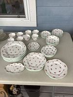Assortment of Shelley Rosebud plates, bowls, cups and saucers arranged on table