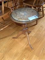 Complete view of side table showing stone top and tripod legs