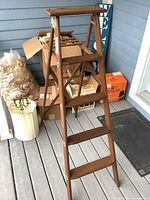 Full view of the wooden step ladder front with treads and tray visible
