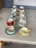 All 10 teacup and saucer sets lined on table