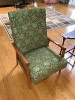 Front angled view of armchair showing upholstery pattern and wood frame