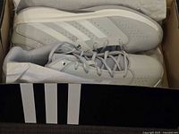 Top view of the pair of grey Adidas sneakers in box